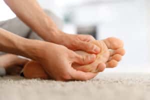 Man hands giving foot massage to yourself to relieve pain