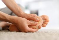 Man hands giving foot massage to yourself to relieve pain